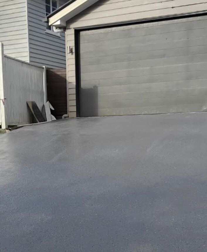 Smooth freshly resurfaced grey concrete driveway