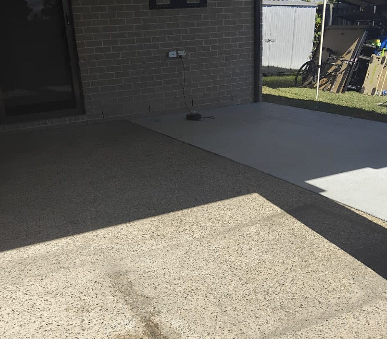 Plain aggregate concrete patio before resurfacing