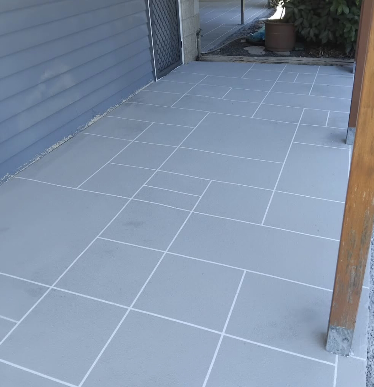 Grey tile-pattern stencil patio after resurfacing