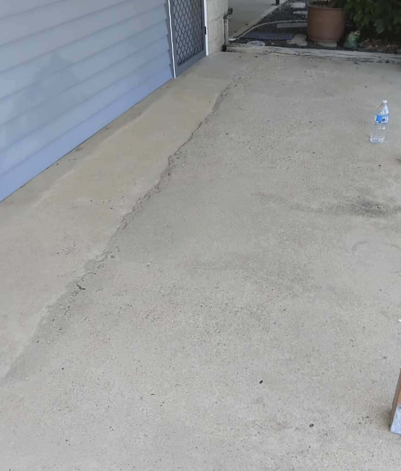 Cracked, stained patio slab before resurfacing